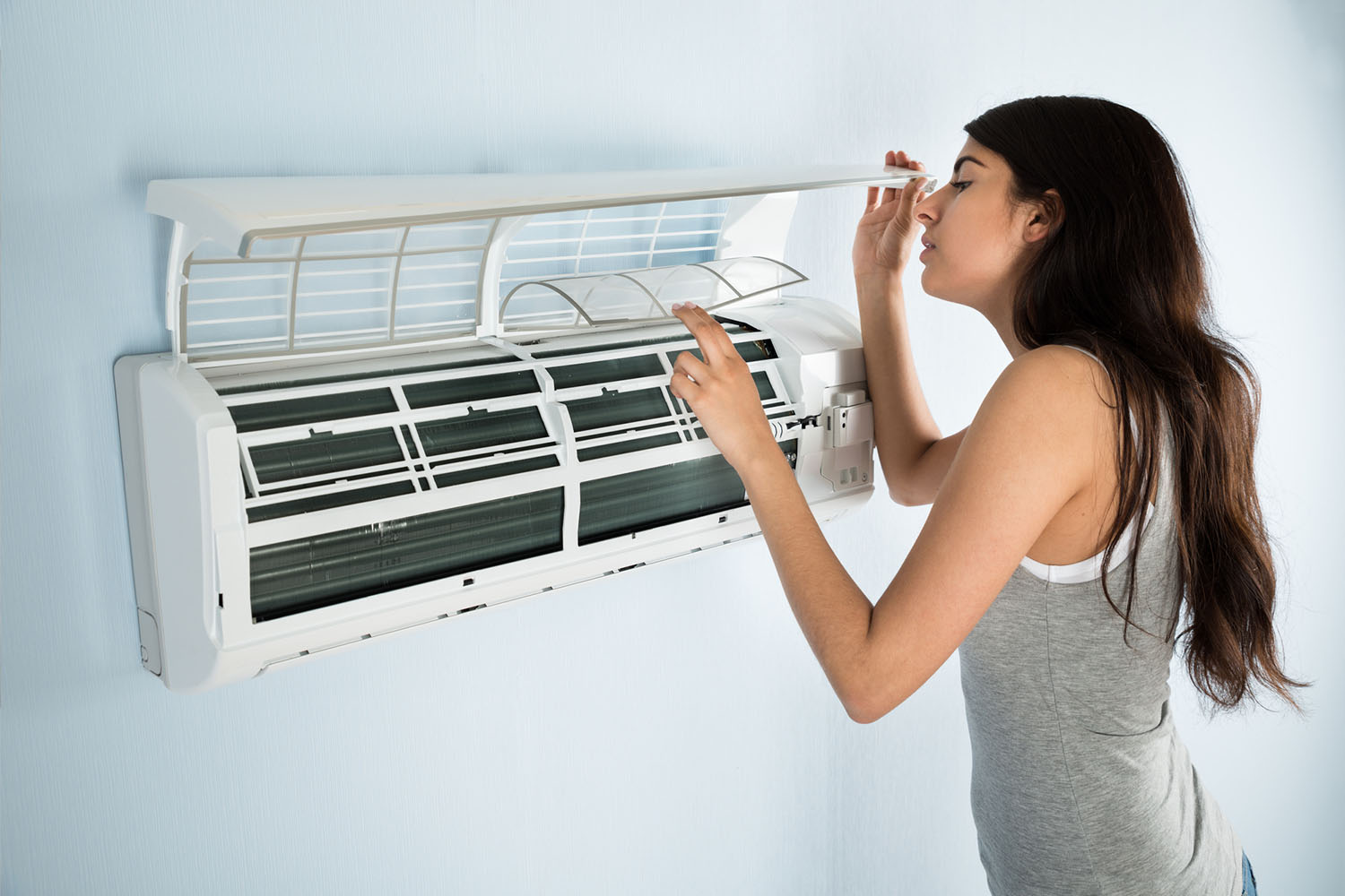woman checking her air conditioning filter